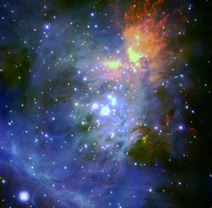 Image of the Orion Nebula with four bright stars (Trapezium) bathed in blue gases in the center and an explosion of yellow and orange above and to the right of the Trapezium.